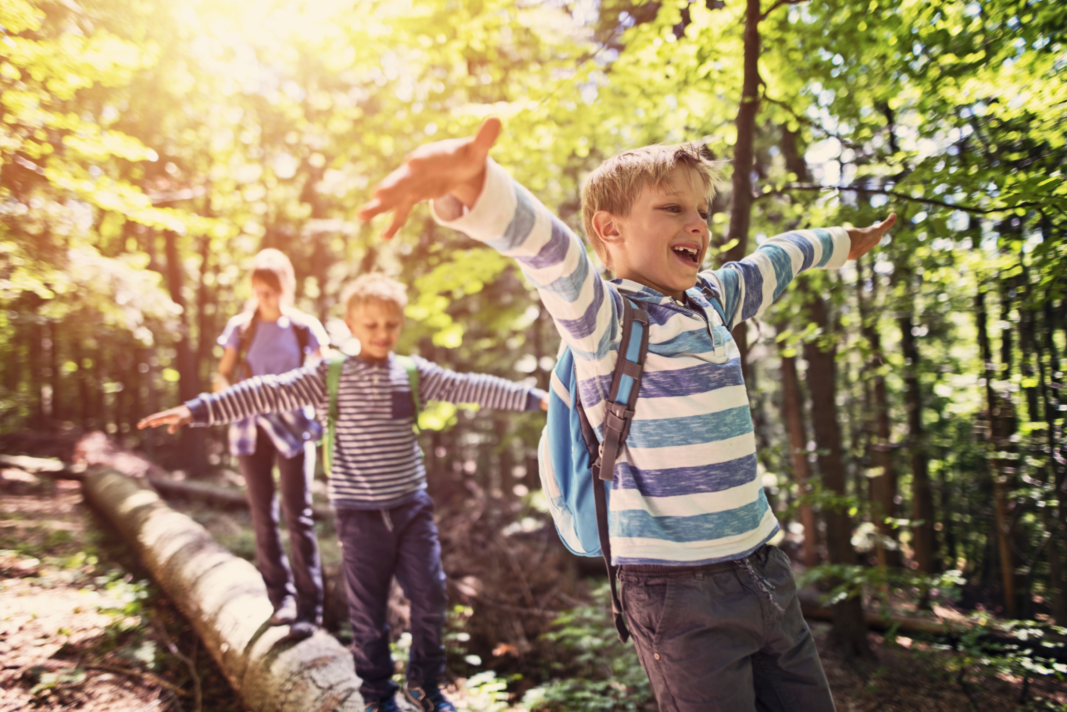 Happy children enjoying a supervised excursion in nature. Daimler Truck supports working parents with reliable childcare and family-friendly offers.